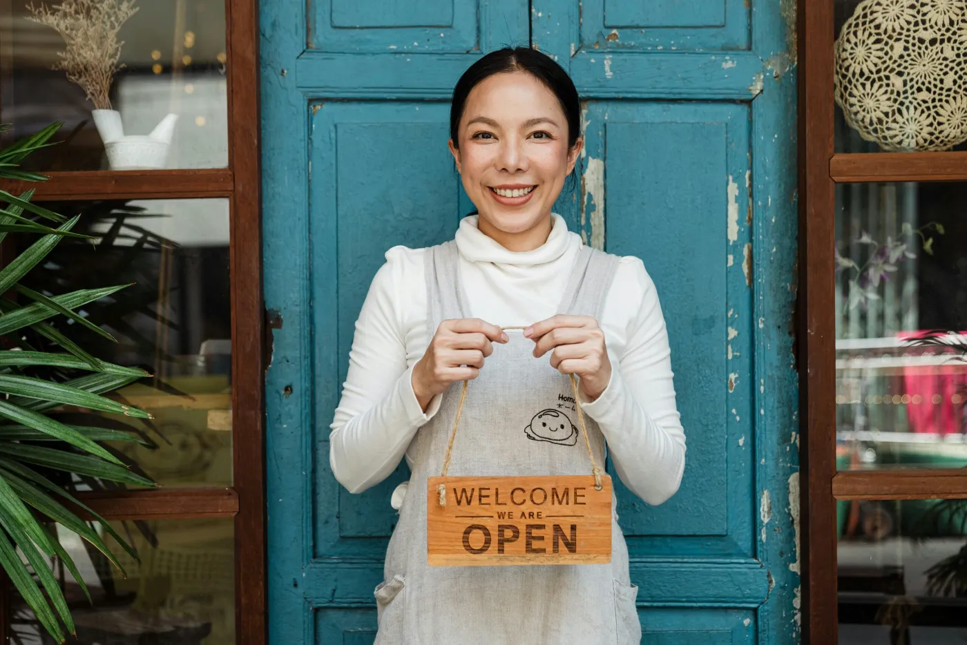Small business owner standing in her shop doorway